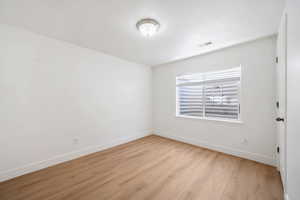 Unfurnished room featuring light wood-style floors and baseboards