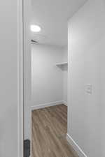 Spacious closet with light wood finished floors and attic access