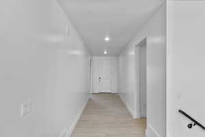 Hallway featuring light wood-type flooring and recessed lighting