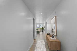 Hall with recessed lighting and light wood-type flooring