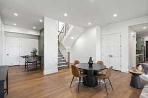 Dining area featuring recessed lighting, wood finished floors, and stairs