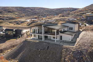 View of front of house featuring a metal roof, a patio, a mountain view, and driveway