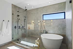 Bathroom featuring a freestanding bath, a stall shower, and recessed lighting