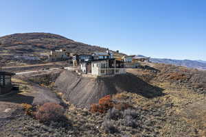 Rear view of property with a mountain view and a balcony