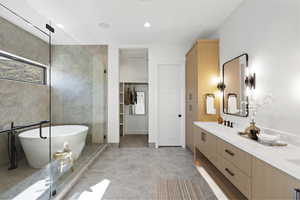 Primary bathroom with a shower stall, double vanity, a soaking tub, recessed lighting, and a walk in closet