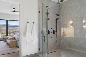 Full bathroom featuring tiled shower, ceiling fan, ensuite bath, a mountain view, and wood finished floors
