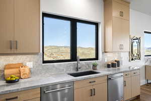 Kitchen with light brown cabinetry and light stone counters