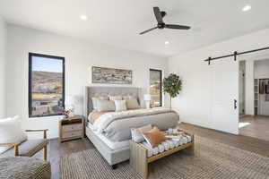 Bedroom with a barn door, wood finished floors, a ceiling fan, and recessed lighting