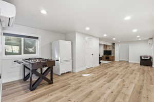 Game room with light wood-type flooring and recessed lighting. 2nd fridge included. Could easily be converted to a 2nd kitchen for an ADU