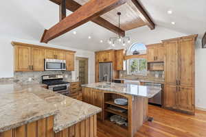 Kitchen with open shelves, appliances with stainless steel finishes, light wood-style floors, light stone counters, and decorative backsplash