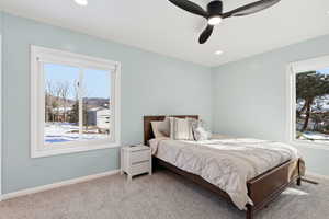 Carpeted bedroom with a ceiling fan and recessed lighting
