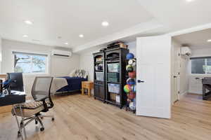 Office space featuring recessed lighting, light wood-type flooring, and a wall mounted air conditioner