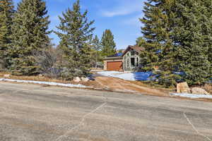 View of front facade featuring solar panels and a garage
