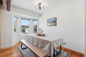 Dining room with light wood finished floors and a chandelier