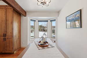 Hallway featuring light wood finished floors and a chandelier