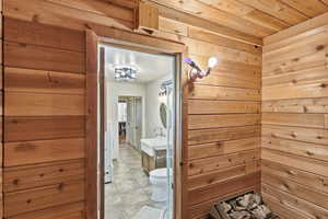 Bathroom with vanity, wood walls, and wooden ceiling