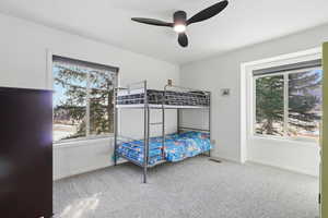 Bedroom featuring light carpet, ceiling fan, and freestanding refrigerator