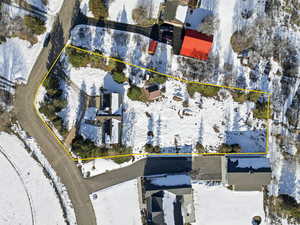 Snowy aerial view featuring property parcel outlined