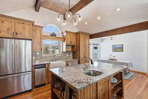 Kitchen featuring open shelves, stainless steel appliances, light stone countertops, backsplash, and beamed ceiling