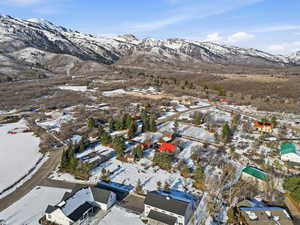 Snowy aerial view with a mountain view and a residential view