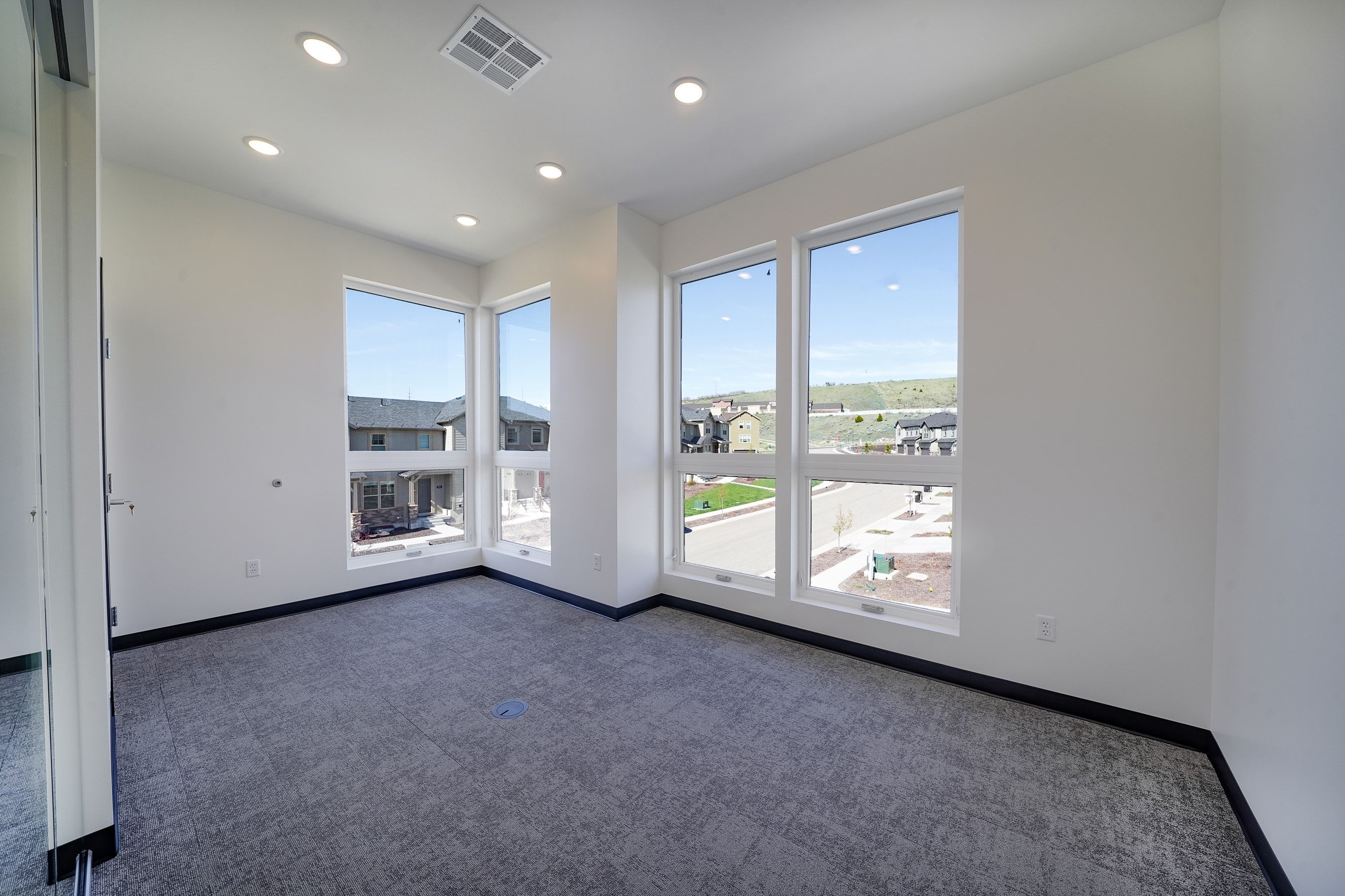 Empty room with dark carpet and recessed lighting