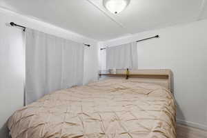Bedroom featuring a textured ceiling and wood finished floors