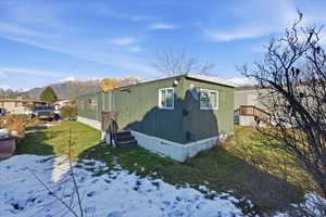 Snow covered property with a lawn and a mountain view