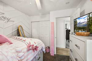 Bedroom featuring light carpet, a closet, a ceiling fan, and a textured ceiling