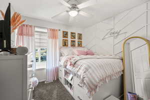 Bedroom with dark colored carpet and a ceiling fan
