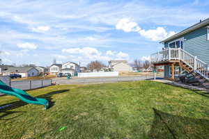 Fenced yard with stairs, a residential view, a playground, a patio, and a wooden deck