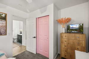 Bedroom featuring dark colored carpet, a closet, and connected bathroom