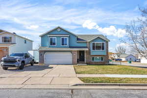 View of front of house featuring brick siding, driveway, roof with shingles, a front lawn, and an attached garage