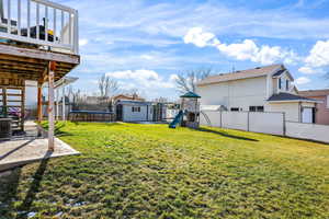 Fenced backyard featuring a storage shed, a trampoline, a playground, and a patio area