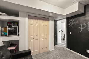 Living area featuring carpet and a textured ceiling