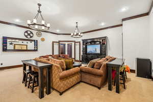 Living room featuring light carpet, a chandelier, ornamental molding, and recessed lighting