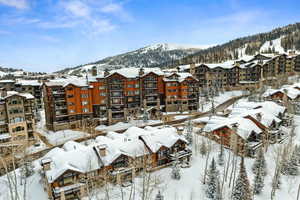 Snowy aerial view featuring a mountain view and a residential view