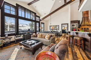 Living room featuring beam ceiling, dark wood finished floors, high vaulted ceiling, recessed lighting, and a chandelier