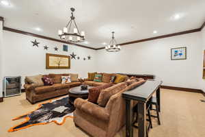 Living area with light carpet, ornamental molding, and recessed lighting
