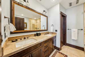 Bathroom with a shower stall, double vanity, light tile patterned flooring, and recessed lighting