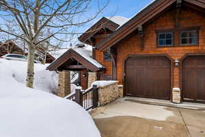 Rustic home with a garage, driveway, and stone siding