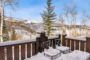 Snow covered deck featuring a mountain view