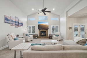 Carpeted living area featuring a fireplace, high vaulted ceiling, a ceiling fan, and plenty of natural light