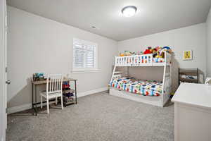 Bedroom featuring baseboards and light carpet