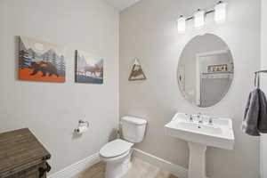 Half bathroom with light tile patterned flooring and toilet