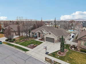 Craftsman house with board and batten siding, a residential view, concrete driveway, stone siding, and an attached garage