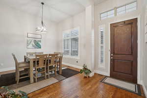 Entrance foyer with wood finished floors and a chandelier