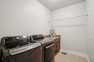 Laundry room featuring light tile patterned floors and independent washer and dryer