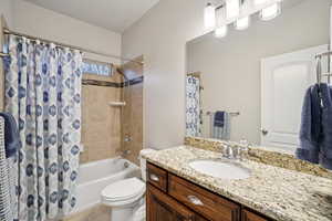 Full bath with shower / tub combo, vanity, and light tile patterned floors