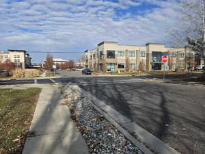 View of asphalt street with traffic signs, sidewalks, and curbs