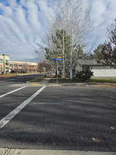 View of asphalt street with curbs, sidewalks, and a mountain view